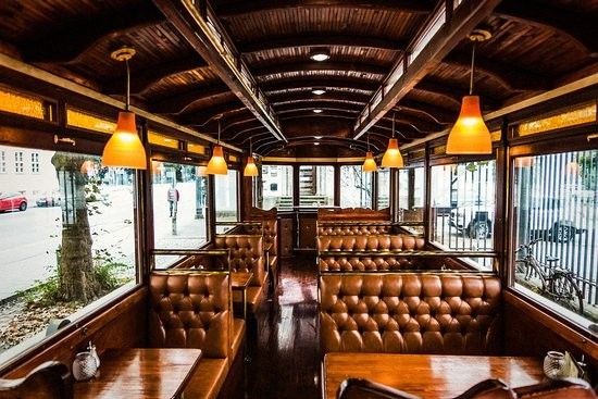 the inside of a restaurant with leather booths and wooden tables, along with large windows