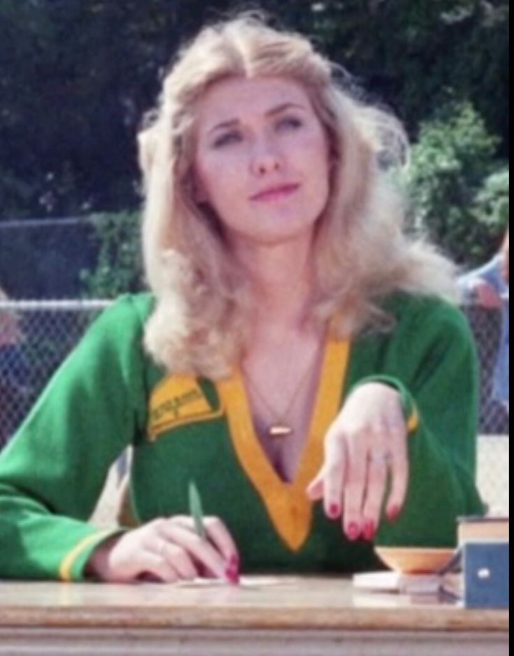 a woman sitting at a table with a pen in her hand