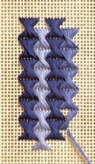 two rows of blue and white yarn next to each other on a beige surface with an orange thread