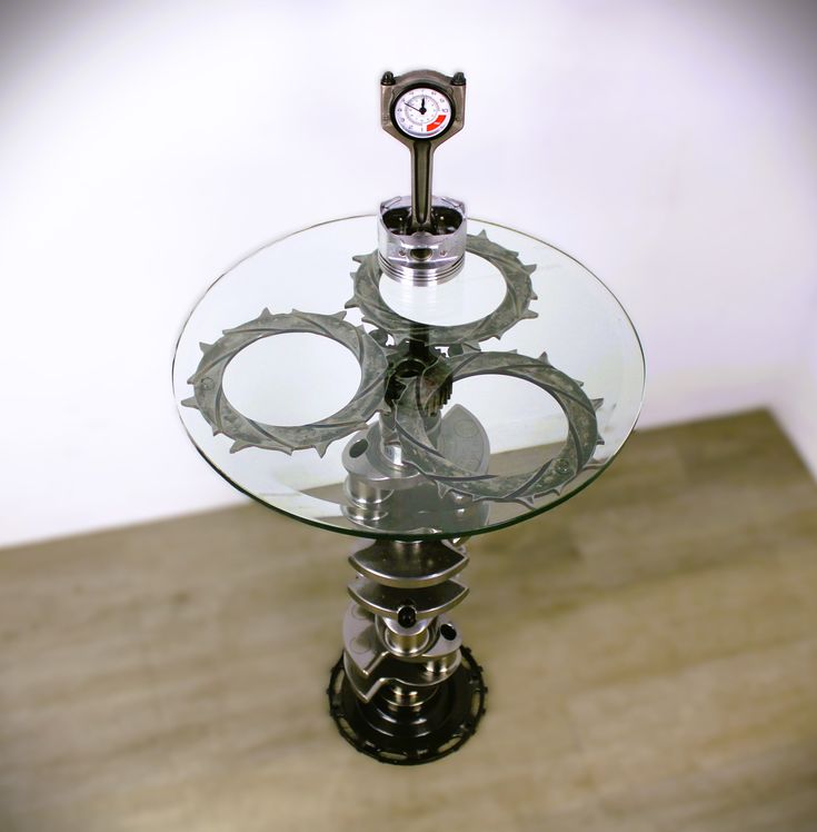 a glass and metal table with a clock on top