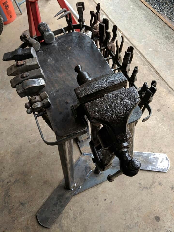 a metal bench with lots of tools attached to it's back end and on the ground