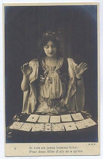 an old photo of a woman sitting at a table with cards