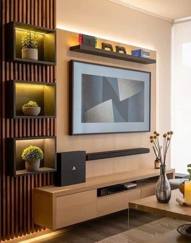 a living room with a large flat screen tv on the wall and shelves filled with vases