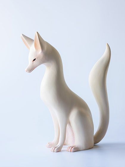 a white cat figurine sitting on top of a table