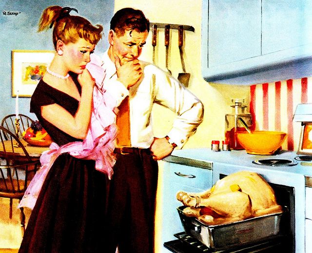 a man standing next to a woman in front of a roasting pan with a turkey on it