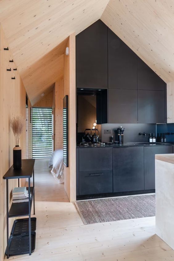 an open kitchen and dining area in a modern house with wooden walls, flooring and ceiling