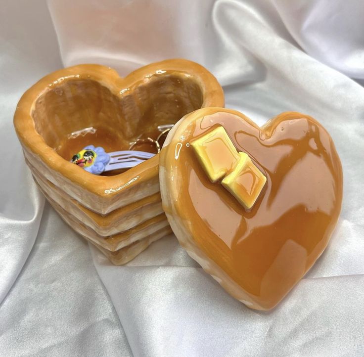 two heart shaped cookies sitting next to each other on top of a white table cloth