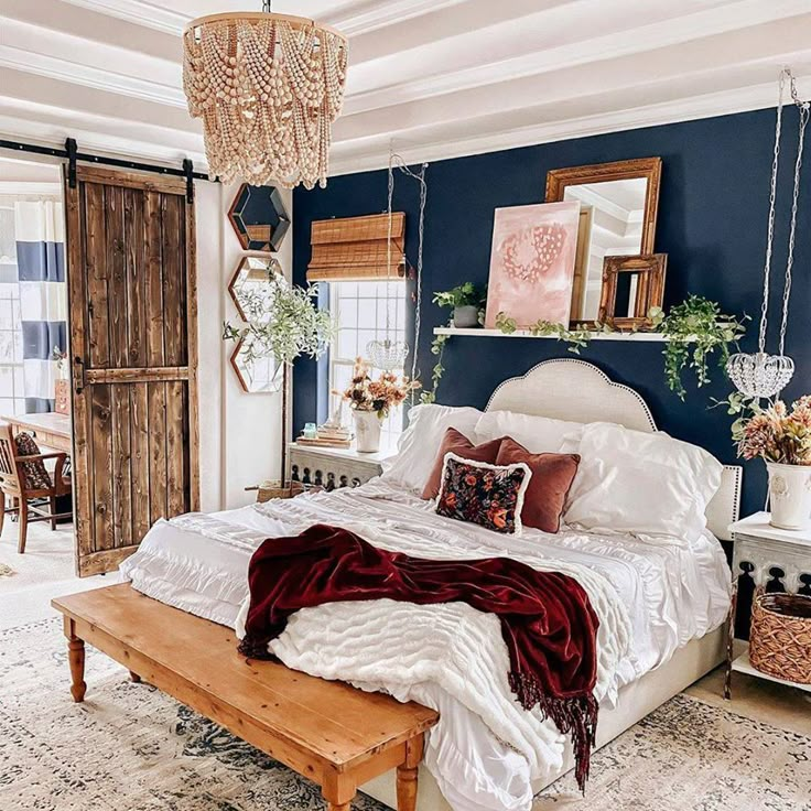 a bedroom with blue walls, white bedding and wooden accents on the ceiling is decorated with hanging plants