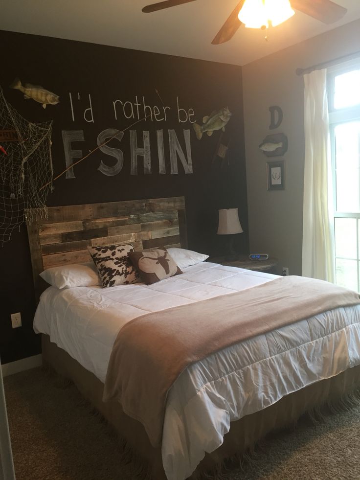 a bed sitting in a bedroom next to a wall with writing on it and a ceiling fan