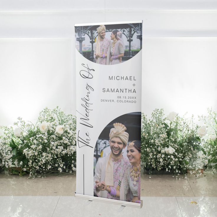 a roll up banner stands in front of some flowers