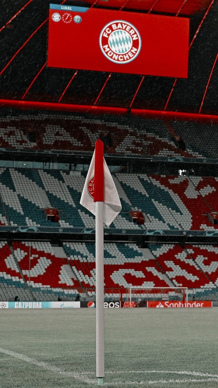 an empty soccer field with a red and white flag