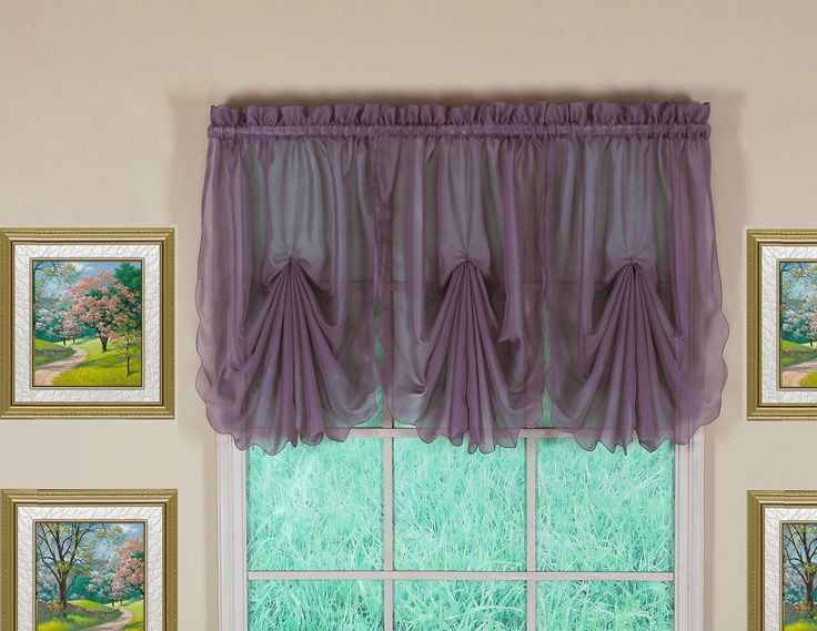 a window with purple curtains and pictures on the wall