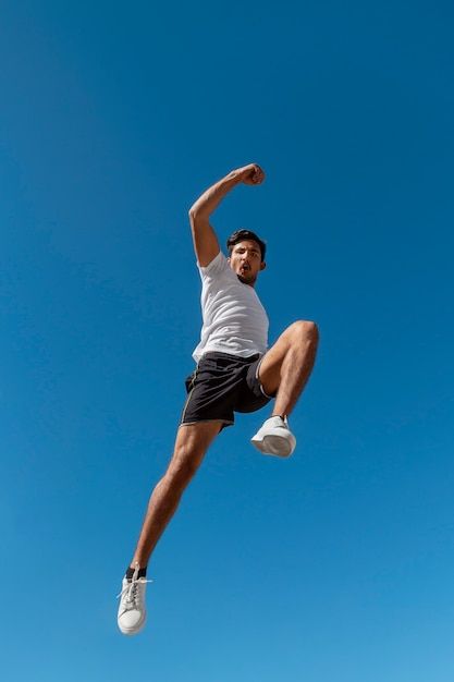 a man is jumping in the air with his feet up and one hand on his hip