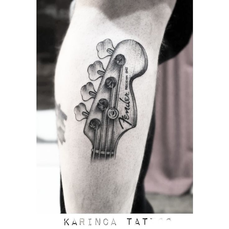 a black and white photo of a guitar tattoo