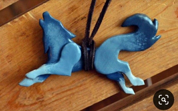 a close up of a blue bird on a wooden table with string attached to it