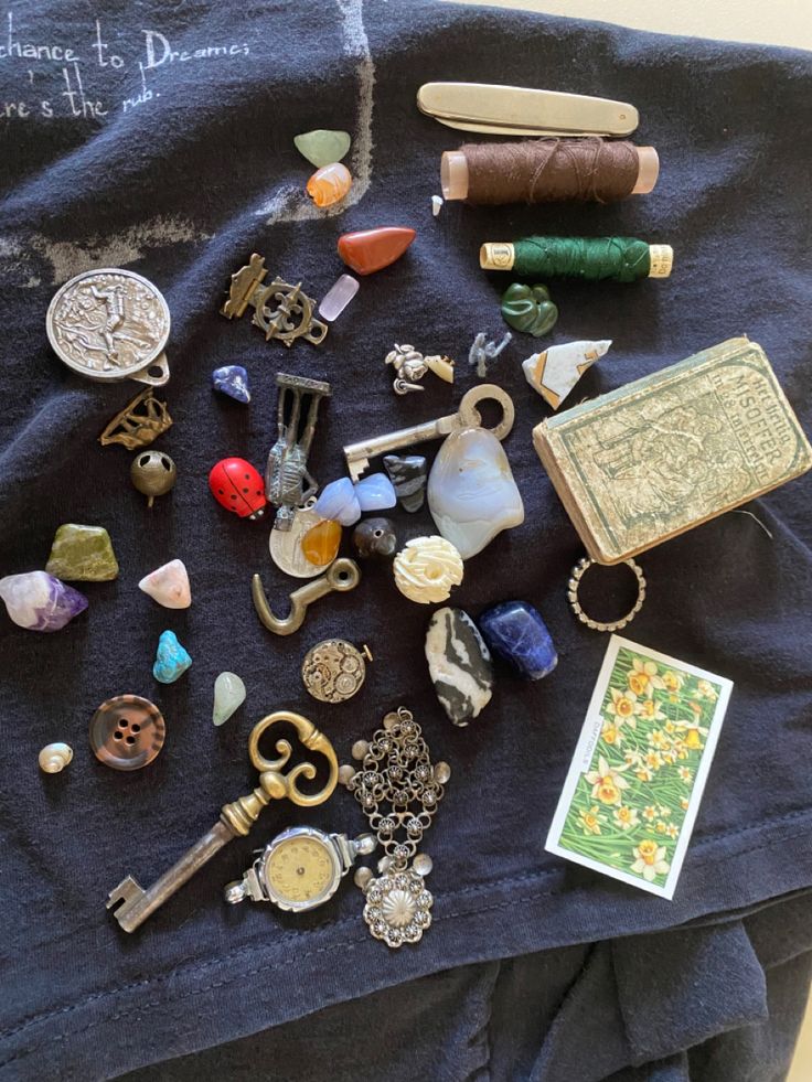 a table topped with lots of assorted items on top of a blue cloth covered table