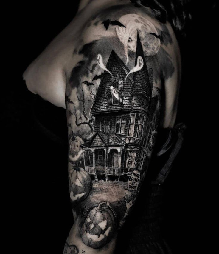 a man's arm with a house and pumpkins on it, in black and white