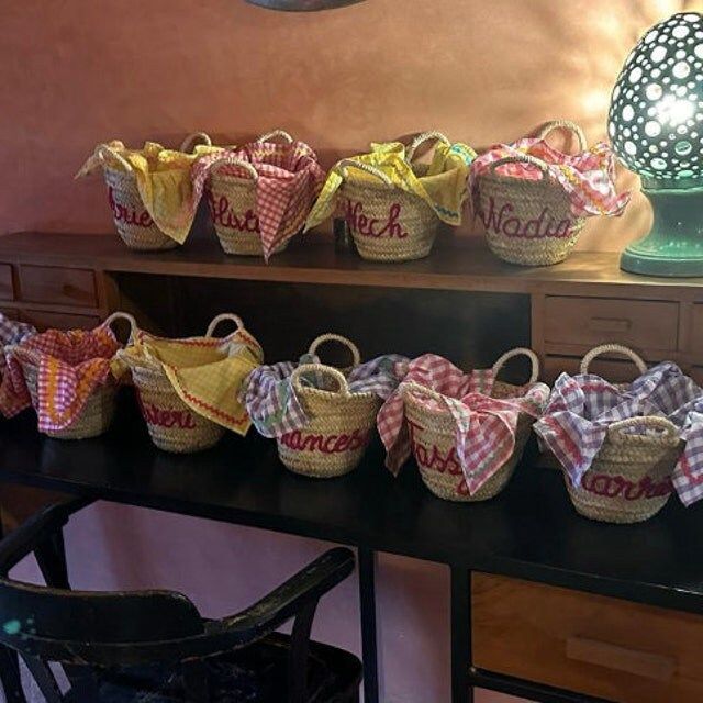 several baskets are lined up on a table in front of a lamp and other items