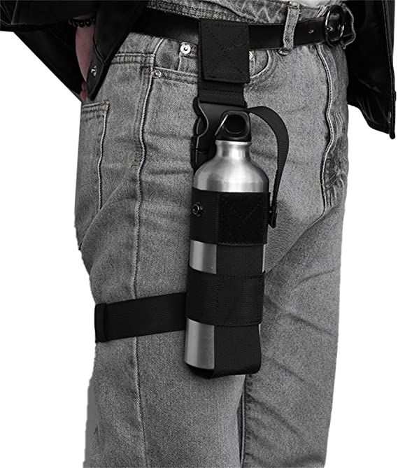 a person wearing grey jeans and black jacket holding a silver water bottle in his pocket