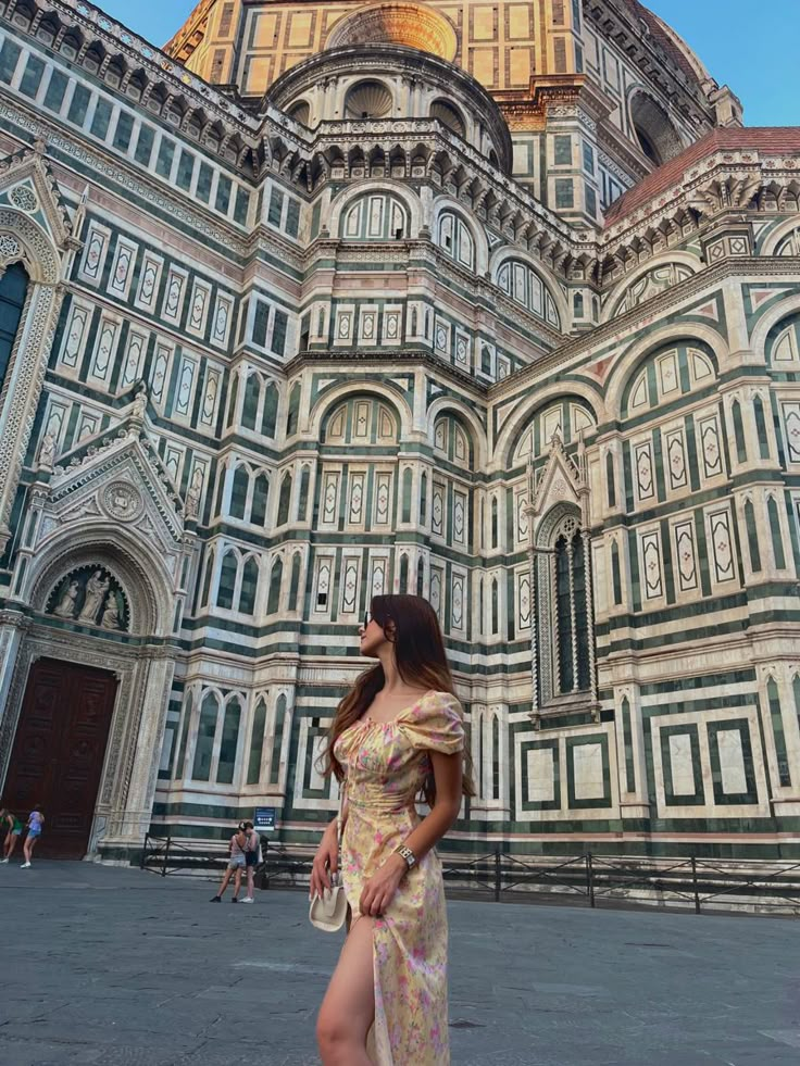 a woman standing in front of a large building