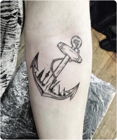 a black and white anchor tattoo on the right leg, with an arrow in the middle