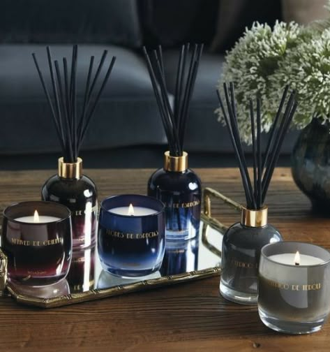 an assortment of candles and bottles on a tray