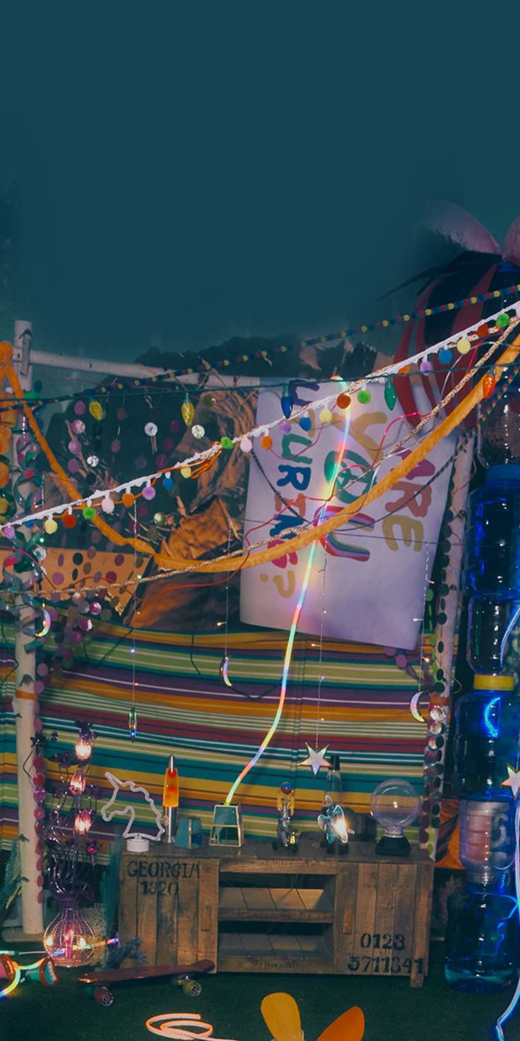 a room filled with lots of balloons and streamers on the wall next to a wooden crate