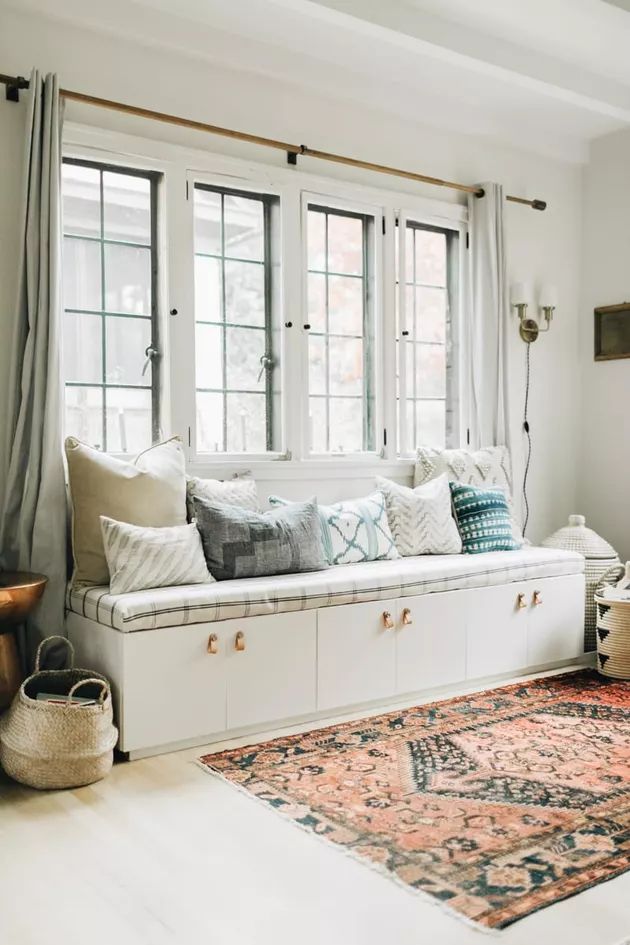 a living room filled with lots of furniture and pillows on top of a white couch