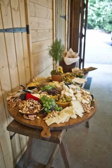 a wooden table topped with lots of different types of cheese and crackers on top of it