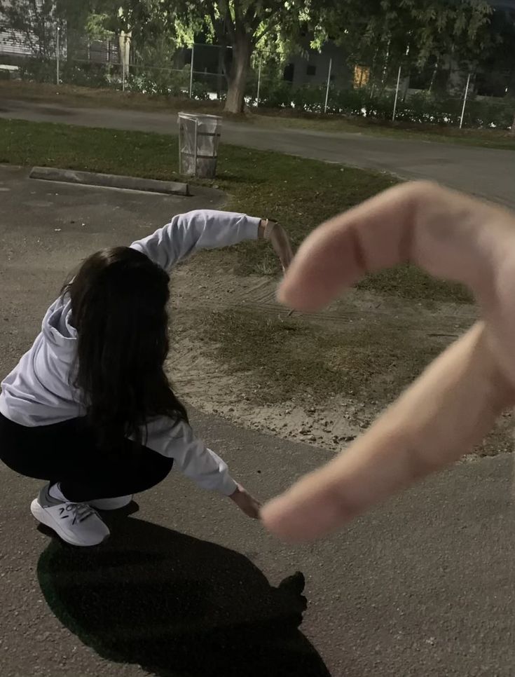 a person reaching out their hand to grab something off the ground in front of them