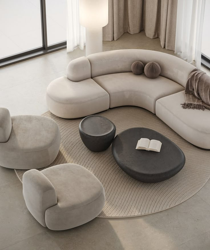 a living room filled with furniture and a book on top of a table in front of a window