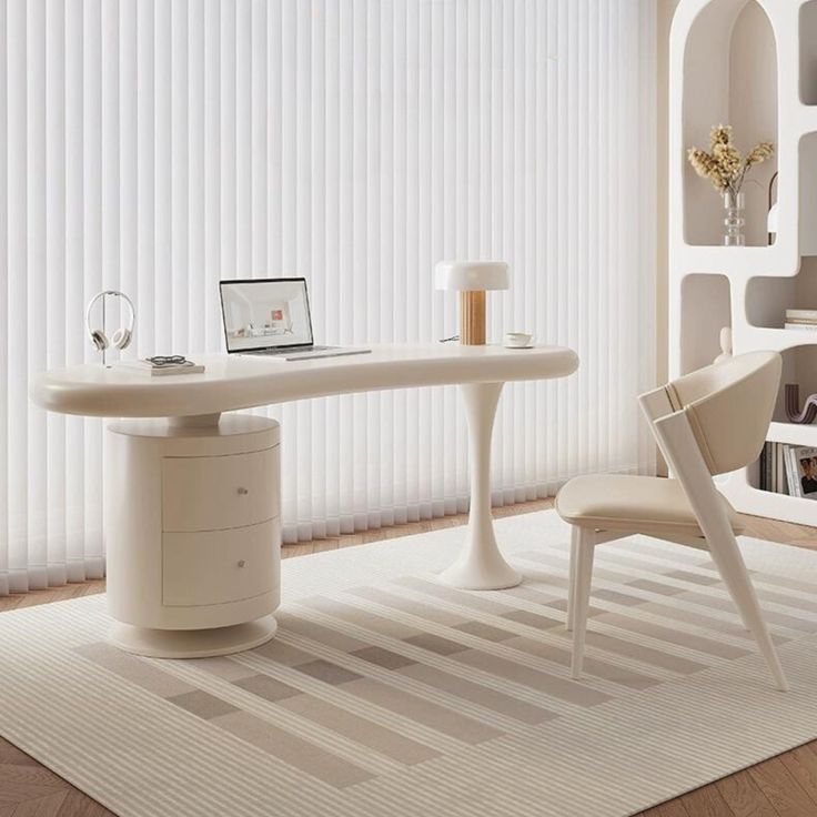 a white table and chair in front of a window with vertical blinds on the windowsill