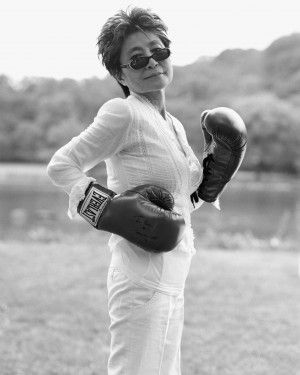 a woman wearing boxing gloves standing in the grass