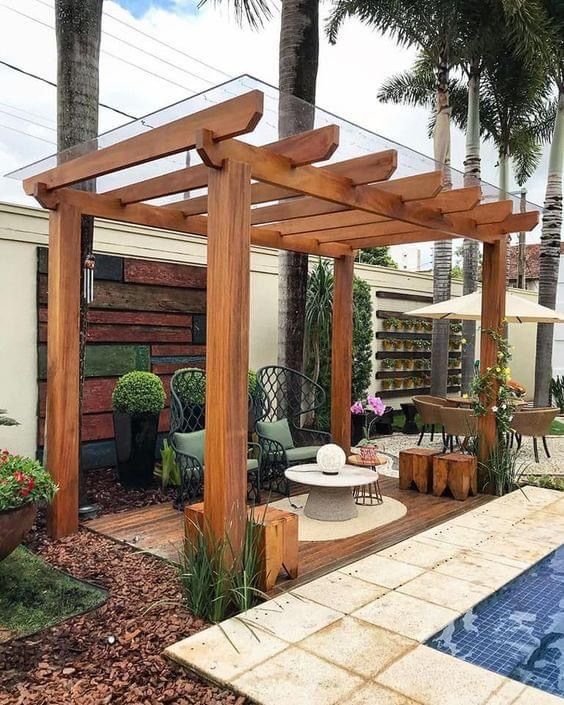 an outdoor living area with a pool and wooden pergol