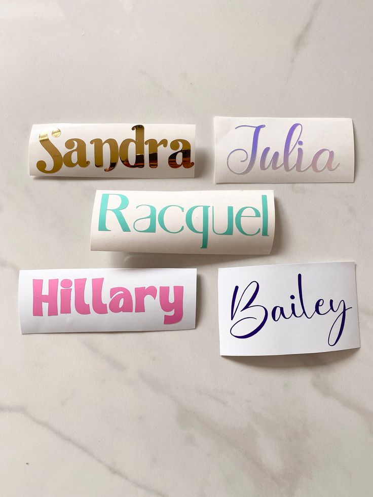 four different name stickers on a marble surface