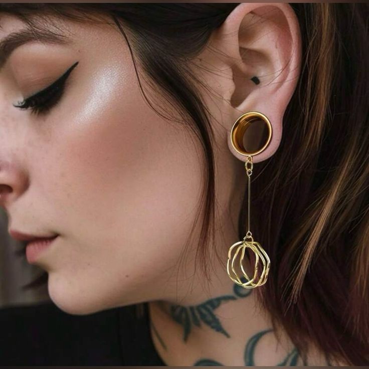 a close up of a person wearing some kind of earring with tattoos on it