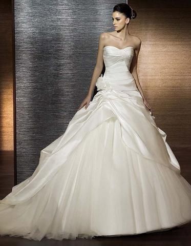 a woman in a white wedding dress posing for the camera