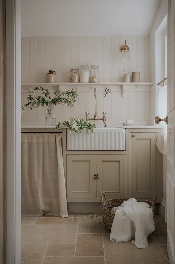 a kitchen with white cabinets and beige tile flooring