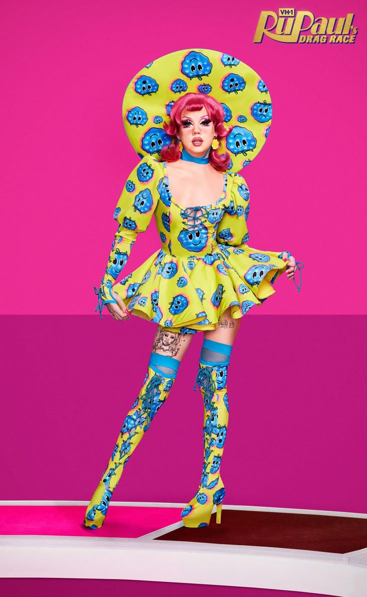 a woman in a yellow dress and blue boots is standing on a pink surface with her arms behind her head