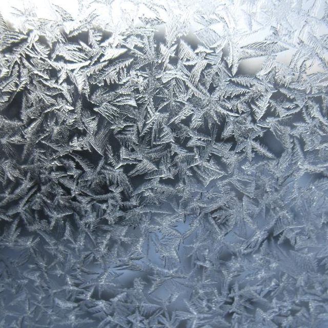 the frosty window is covered with small snowflakes