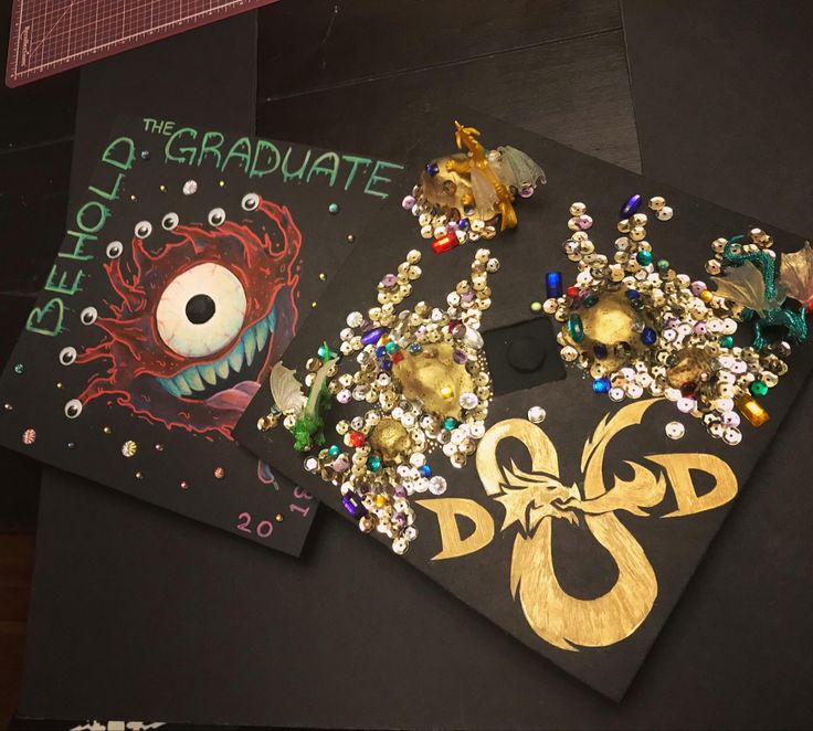 some brooches and other items are laying on a table top with black paper