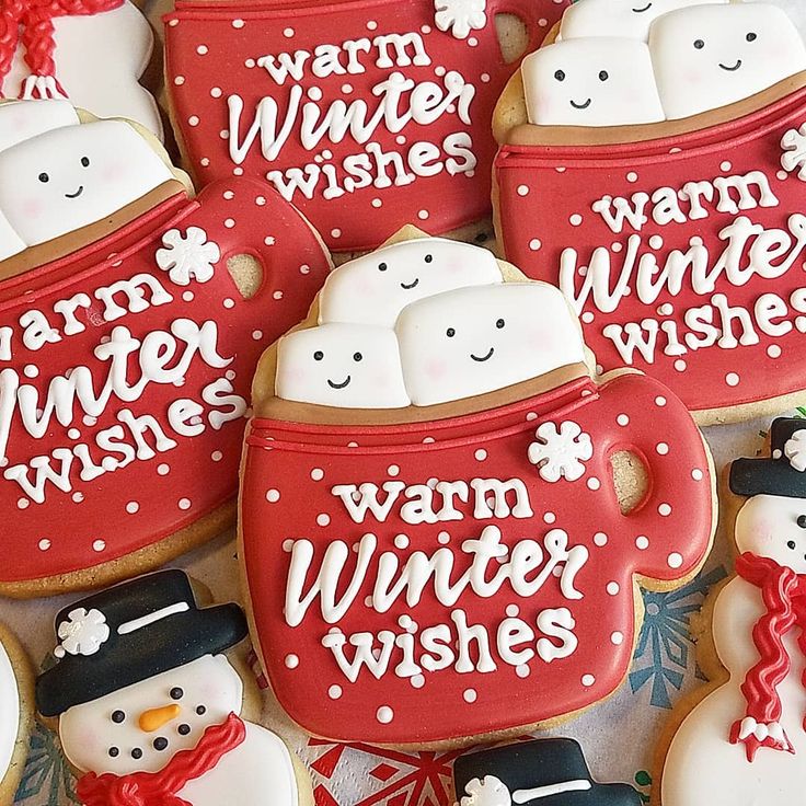 decorated cookies in the shape of mugs and snowmen with words written on them