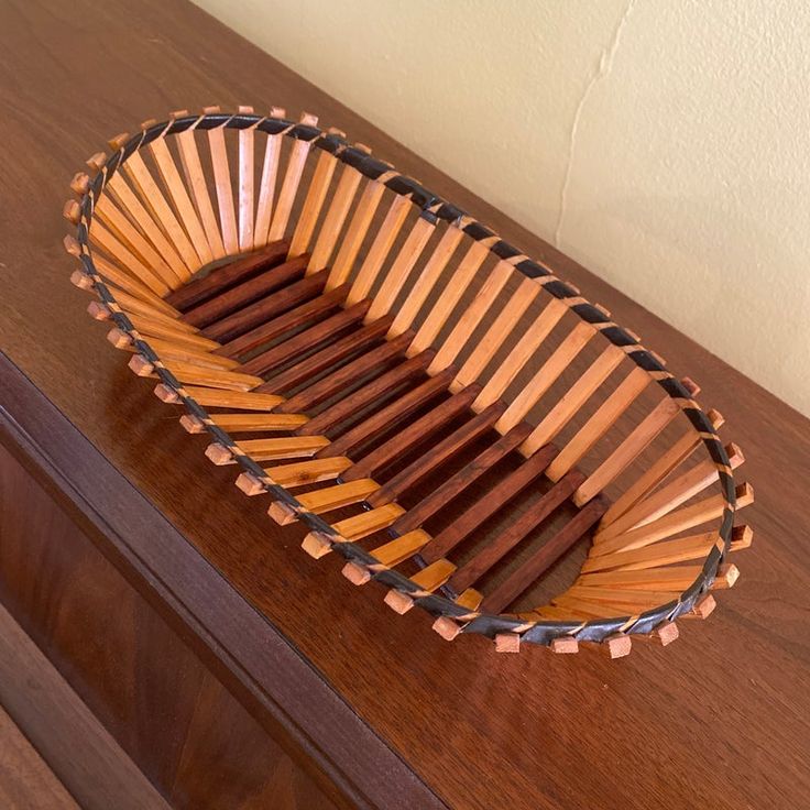 a wooden bowl sitting on top of a table next to a drawer with drawers in it