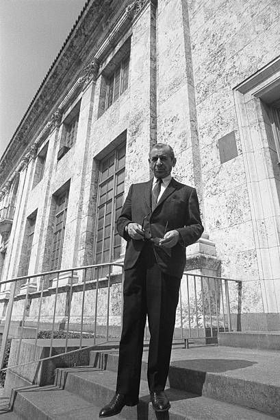 a man in a suit and tie standing on some steps