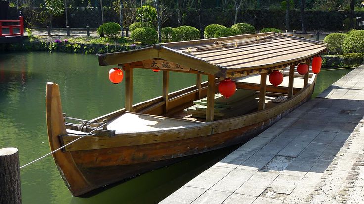 a wooden boat tied up to the side of a body of water with red balls on it