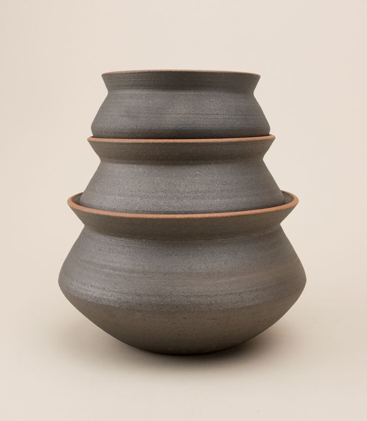 three gray vases stacked on top of each other