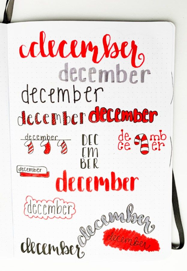 a white notebook with red writing on it and black strap around the edge that says december