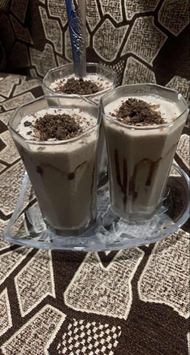 three glasses filled with ice cream and chocolate toppings