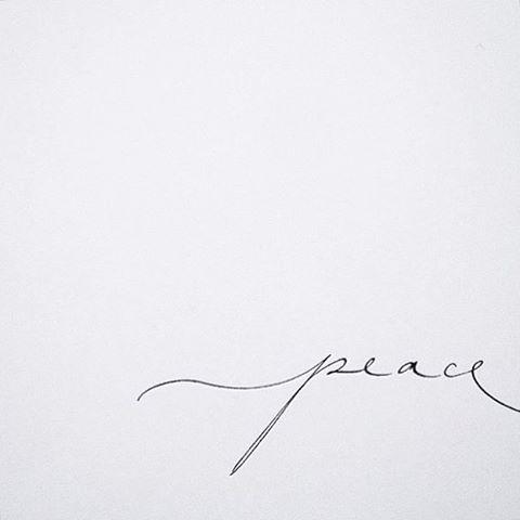 the word peace is written in cursive handwriting