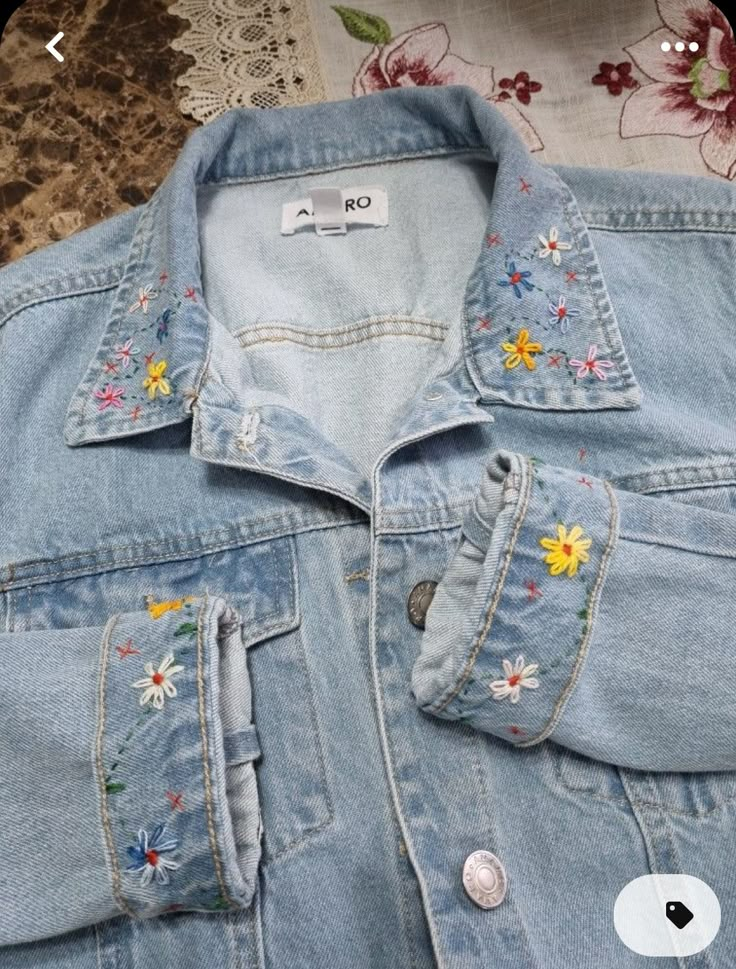 a denim jacket with embroidered flowers on it